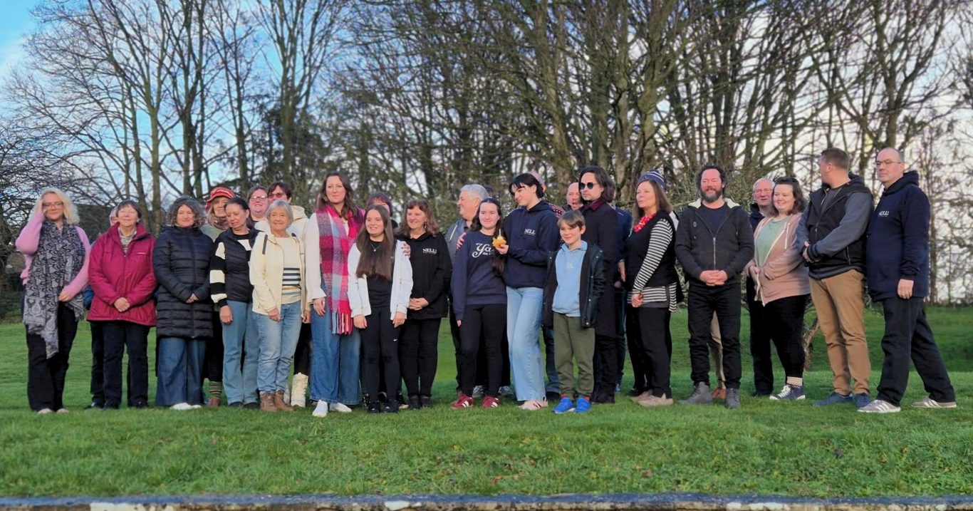 First Cast Photo A group of people wearing casual, lined up for a photo with happy faces.